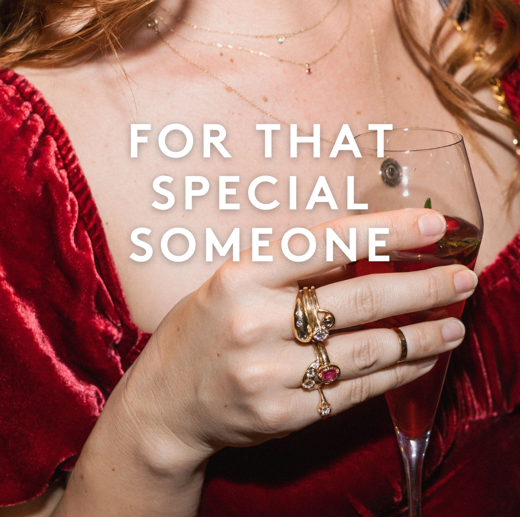 woman holding cocktail with rings and necklaces