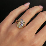 Gold ring with a large diamond on a hand against a black background