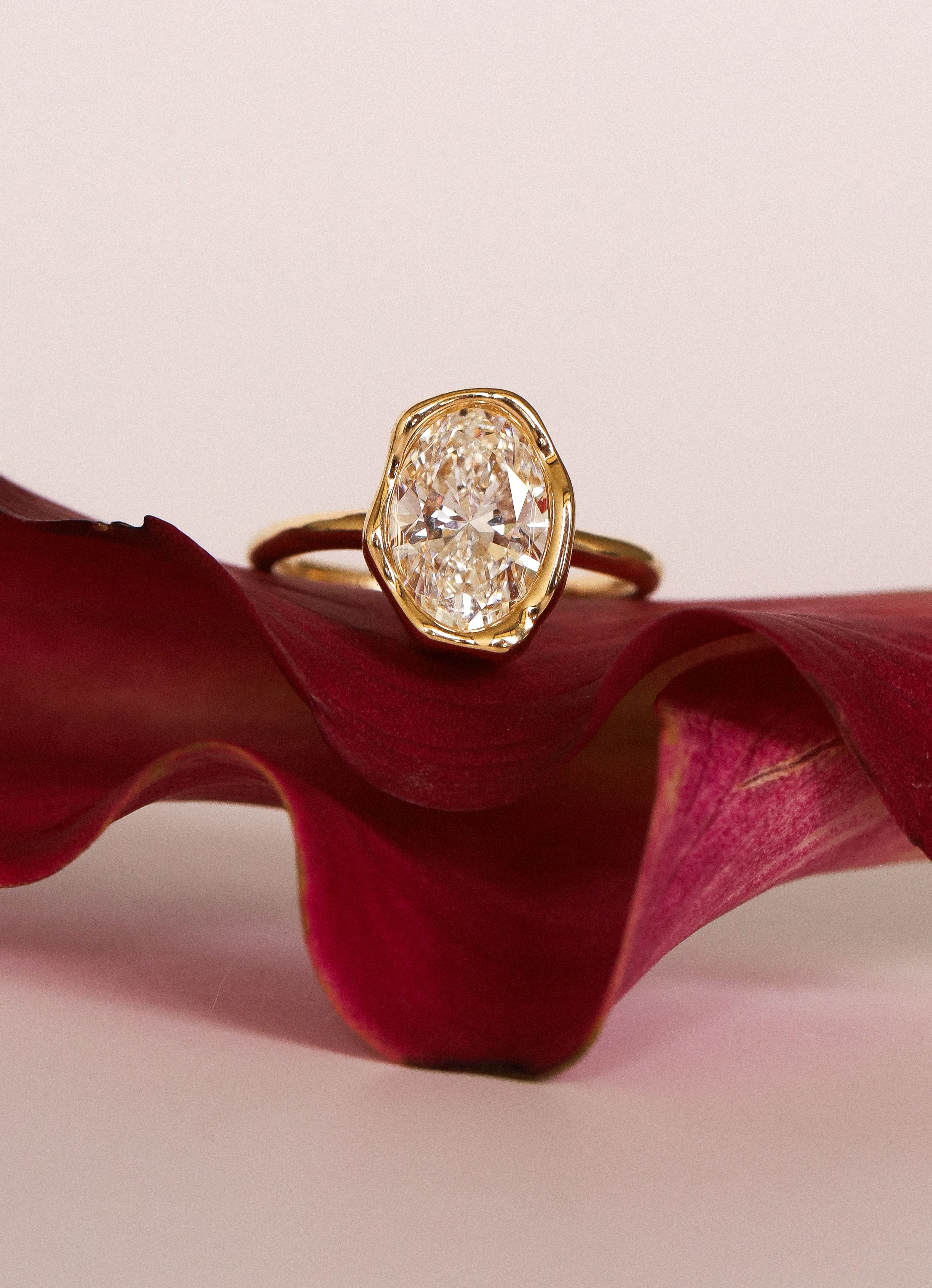 Abstract Bezel Diamond ring flat lay, on a pink flower
