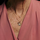 Necklace with a pendant on a person wearing a pink garment