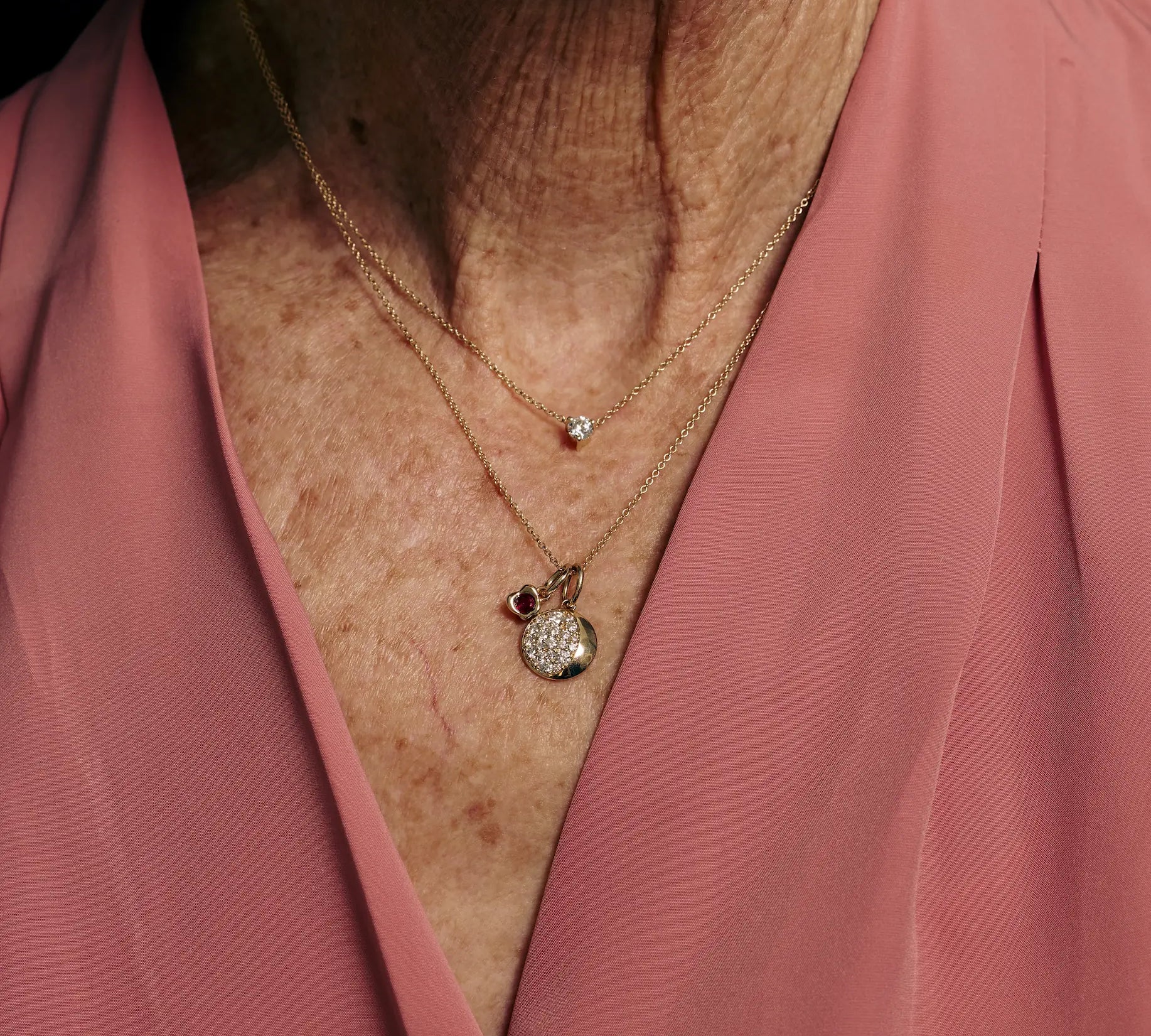 Necklace with a pendant on a person wearing a pink garment