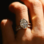 Close-up of a diamond ring on a finger with a dark background