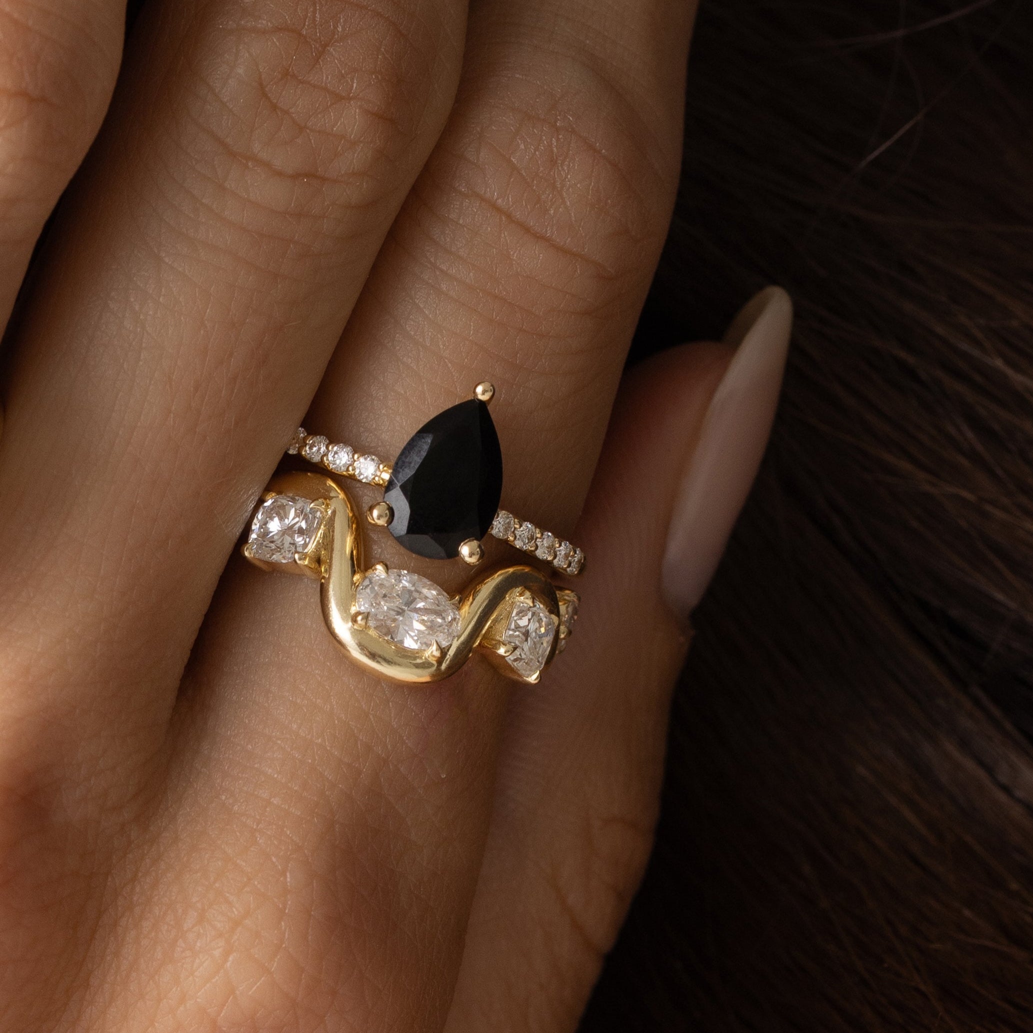 Close up of model with hand resting on her face, featuring Arno Serpentine Band