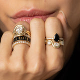 Close up of model with hand resting on her face, featuring Arno Serpentine Band and other Marrow Fine rings