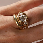 Close-up of hand wearing an open bombe ring with three round diamonds.