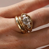 Close-up of hand wearing an open bombe ring with three round diamonds.