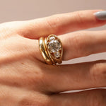 Close-up of hand wearing an open bombe ring with three round diamonds.