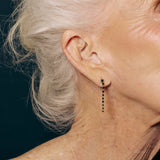 Close-up of a woman wearing an earring with a dark background