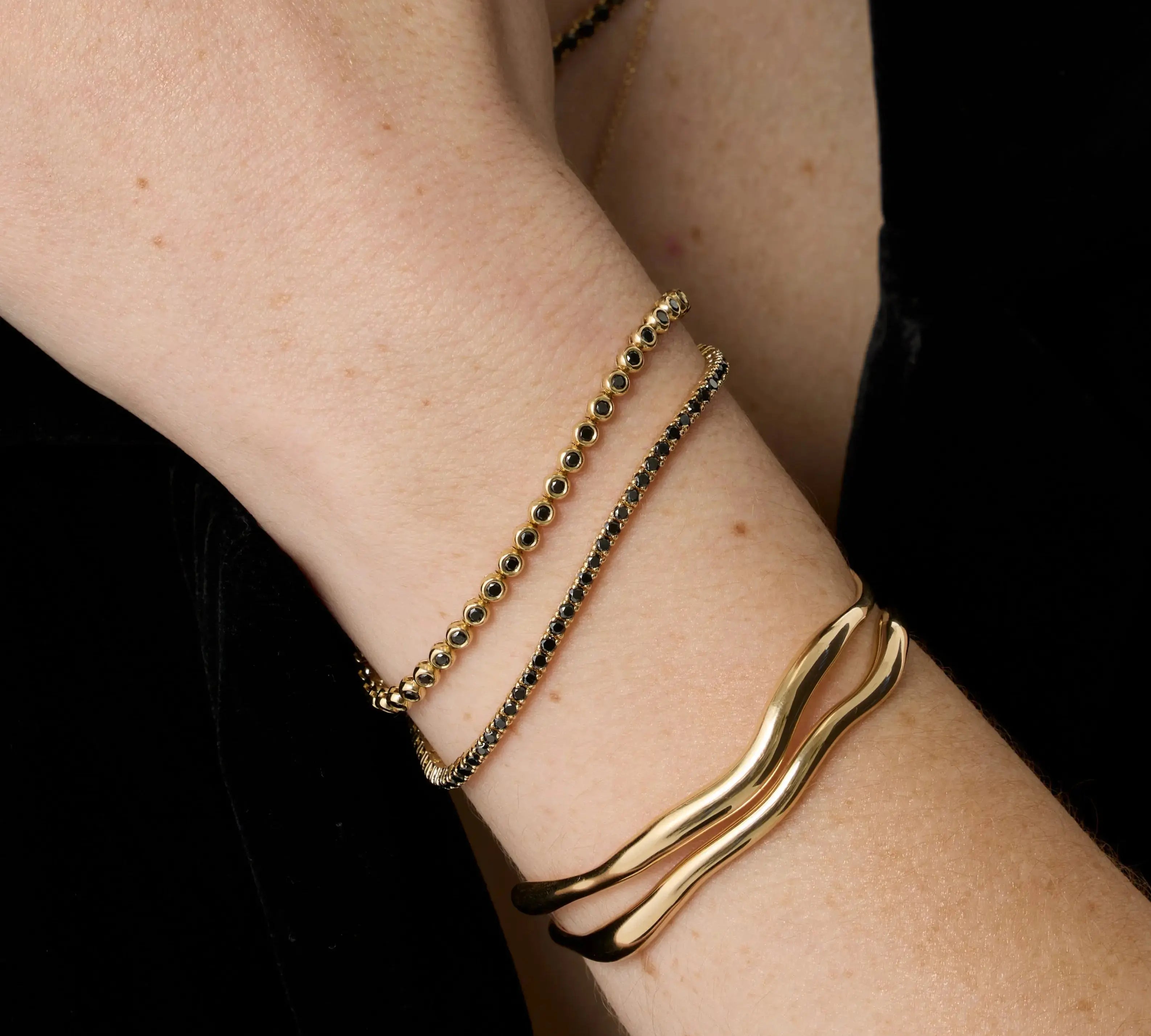 Black Diamond Tennis Bracelet + Black Diamond Bezeled Tennis Bracelet close up on woman's wrist