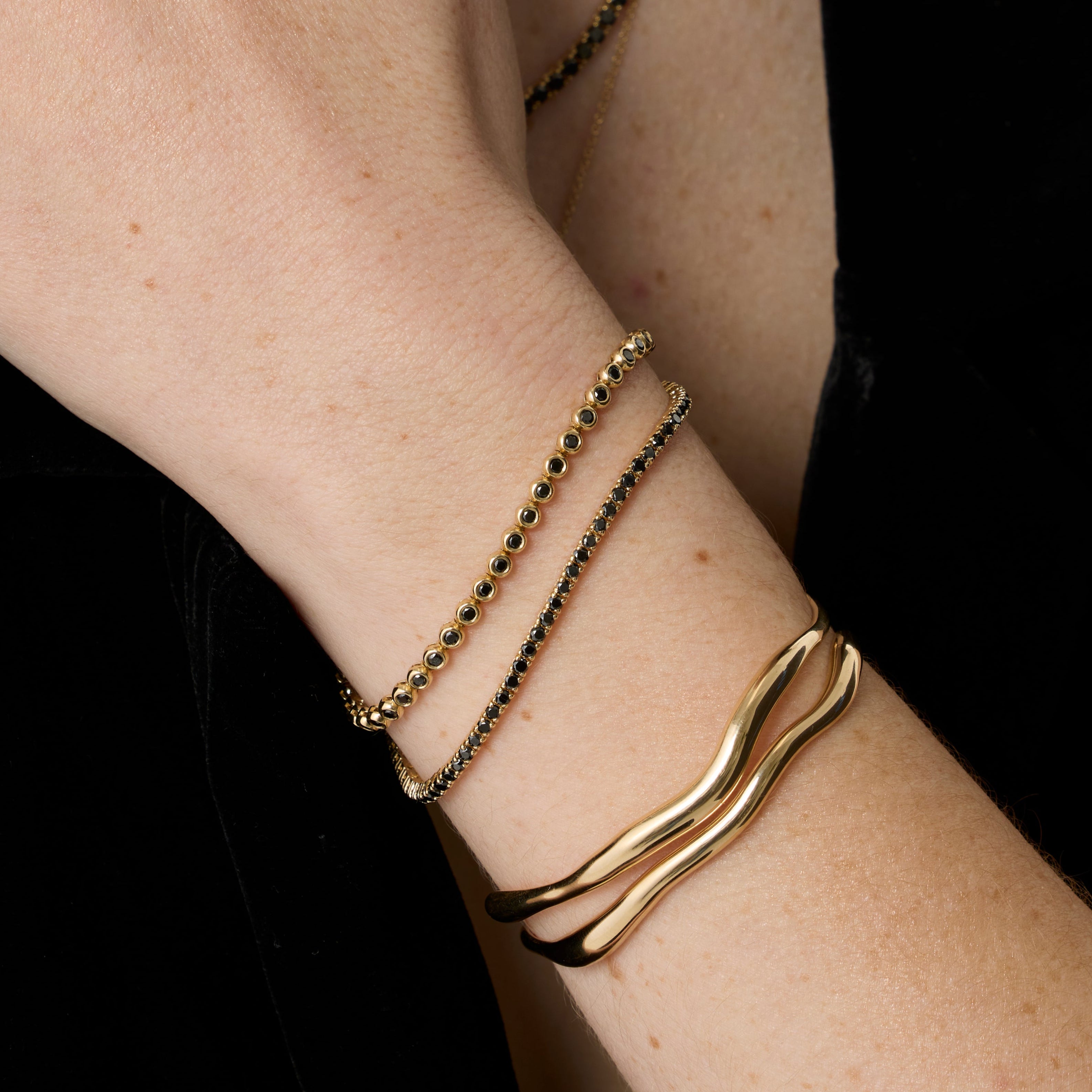 Black Diamond Tennis Bracelet + Black Diamond Bezeled Tennis Bracelet close up on woman's wrist