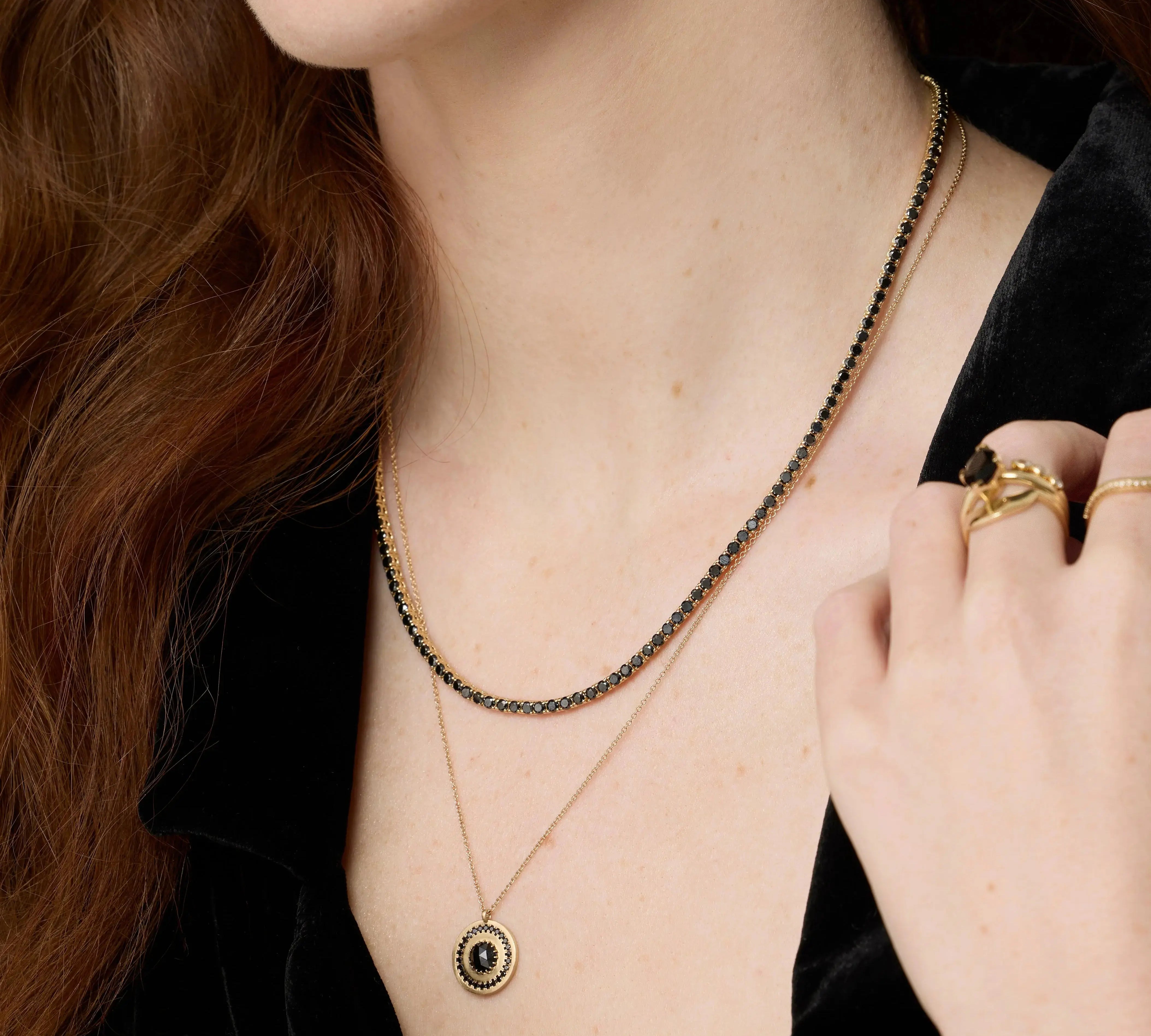 Close up of Black Diamond Tennis Necklace and Black Diamond La Femme Pendant on woman's décolletage 