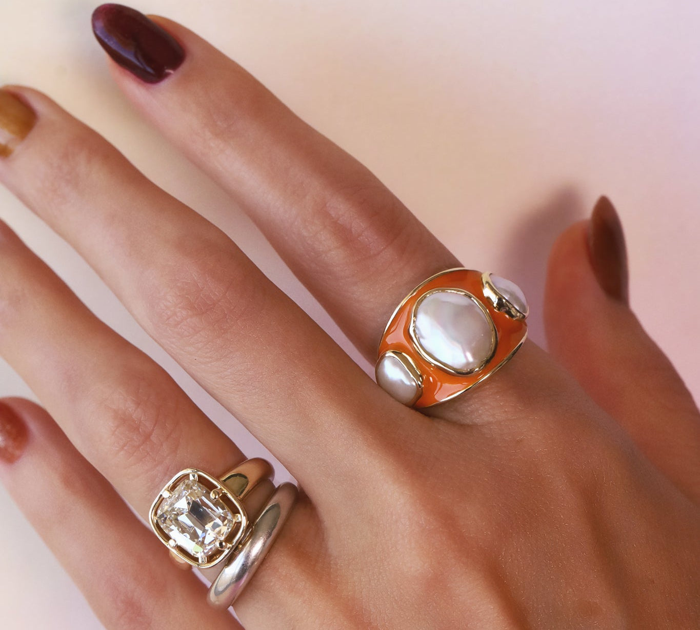 Baroque Keshi Pearl and Burnt Orange Enamel Ring worn on the hand alongside a second ring