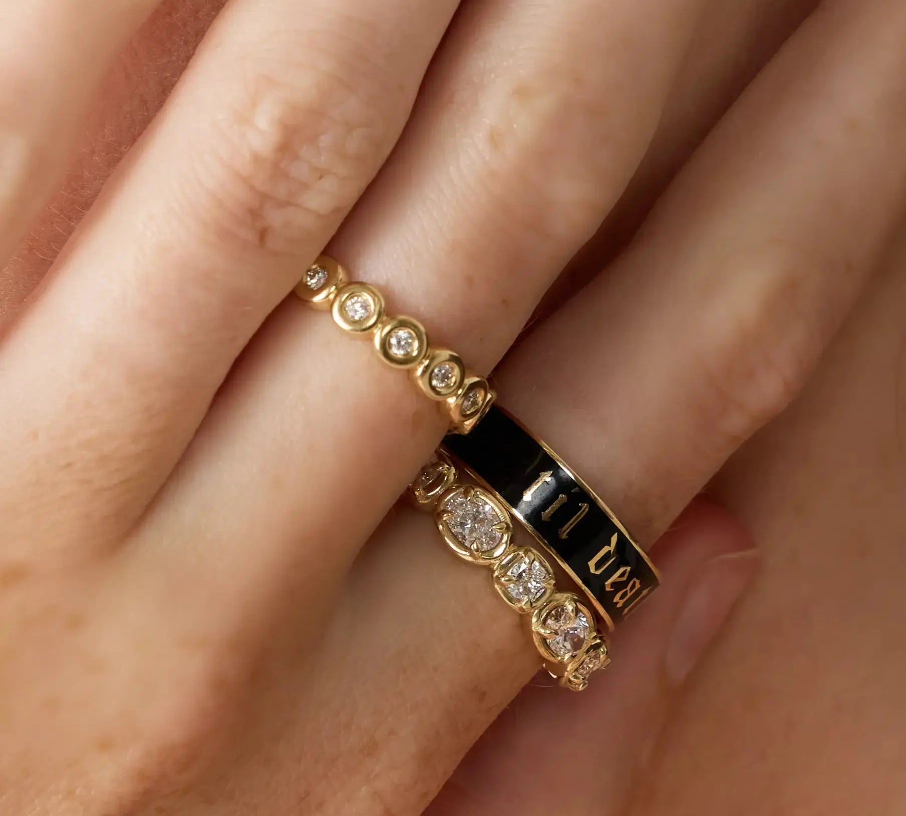 Gold ring with diamond accents on a finger