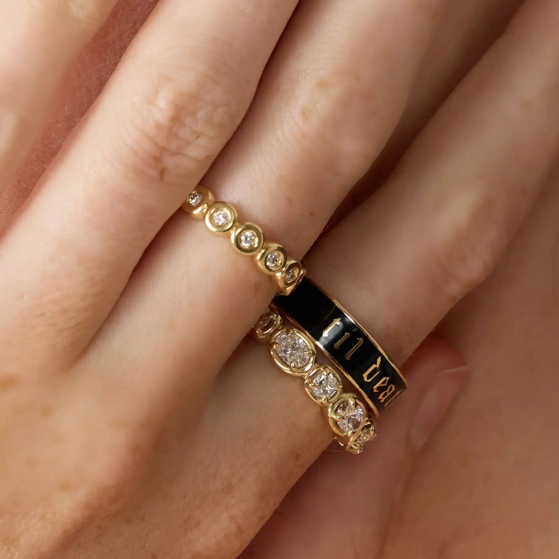 Gold ring with diamond accents on a finger