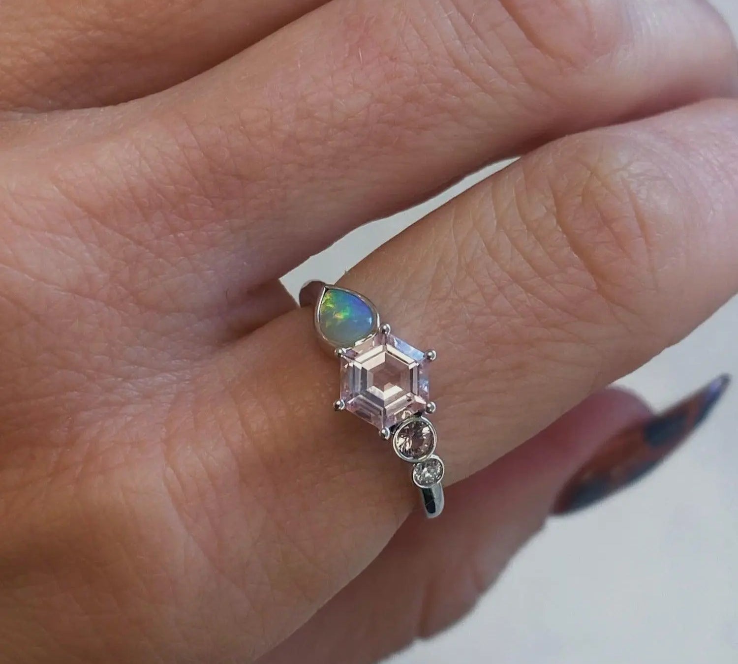 image of a Marrow fine linear ring on a pointer finger. This one of a kind piece is in 14K white gold and has a  hexagon Morganite in the center.