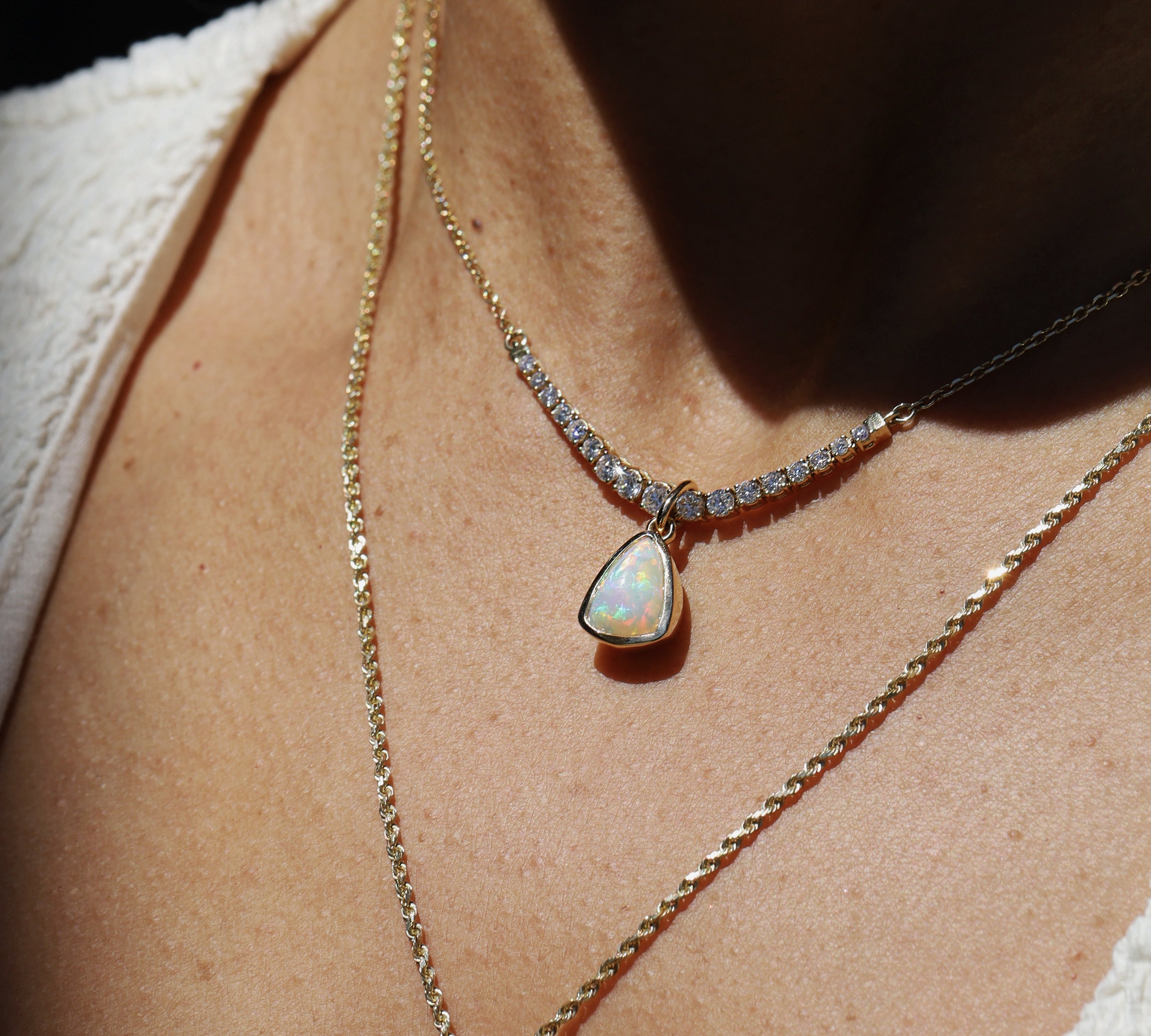 Necklace with an opal pendant worn by a person