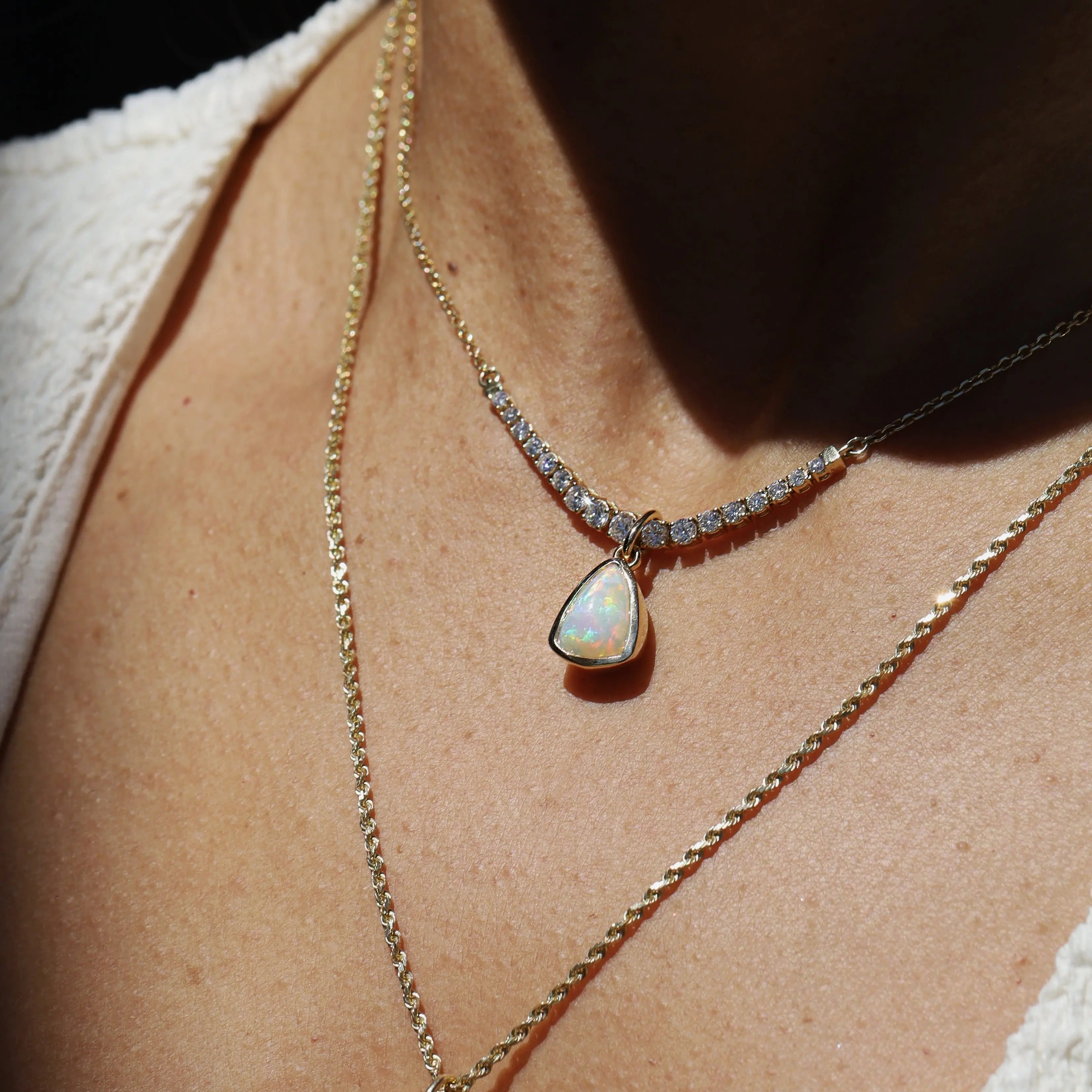 Necklace with an opal pendant worn by a person