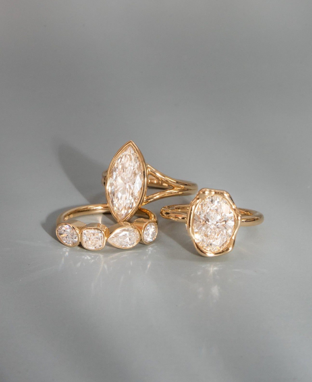 Gold rings with diamond-like stones on a gray background