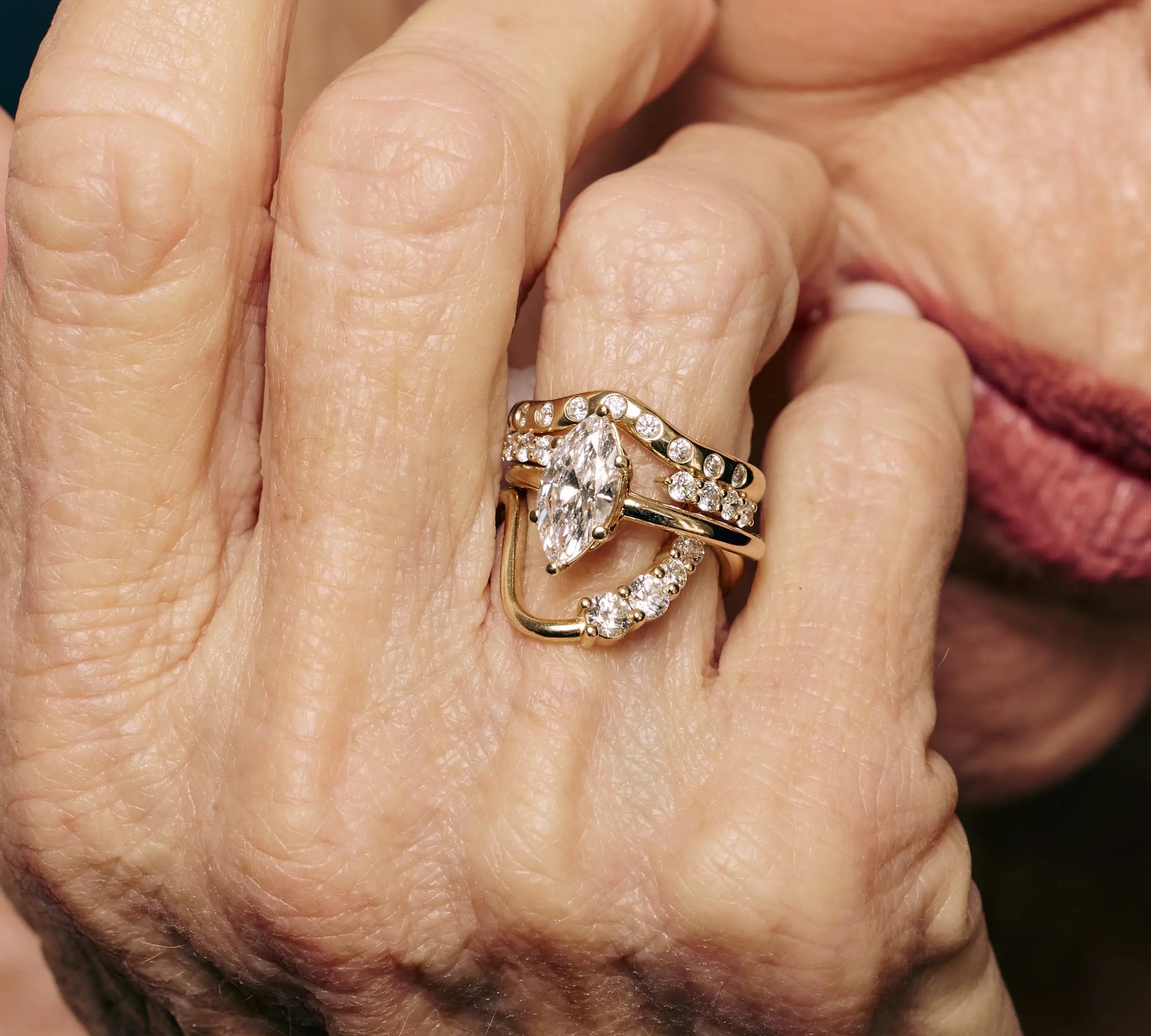 Close-up of a hand wearing a gold ring with diamond accents.