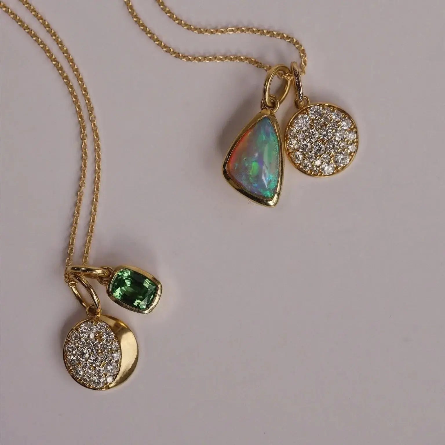 Gold necklace with three pendant charms on a light gray background