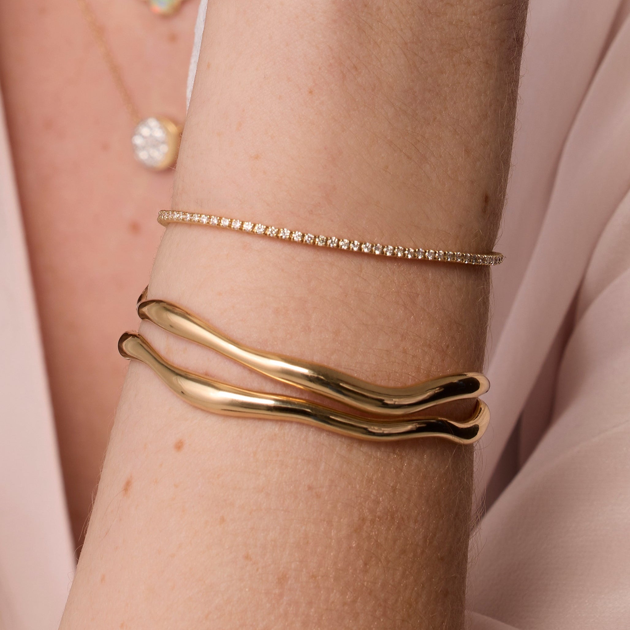 Coco Tennis Bracelet & Curved Freeform Gold Cuff close up of woman's wrist