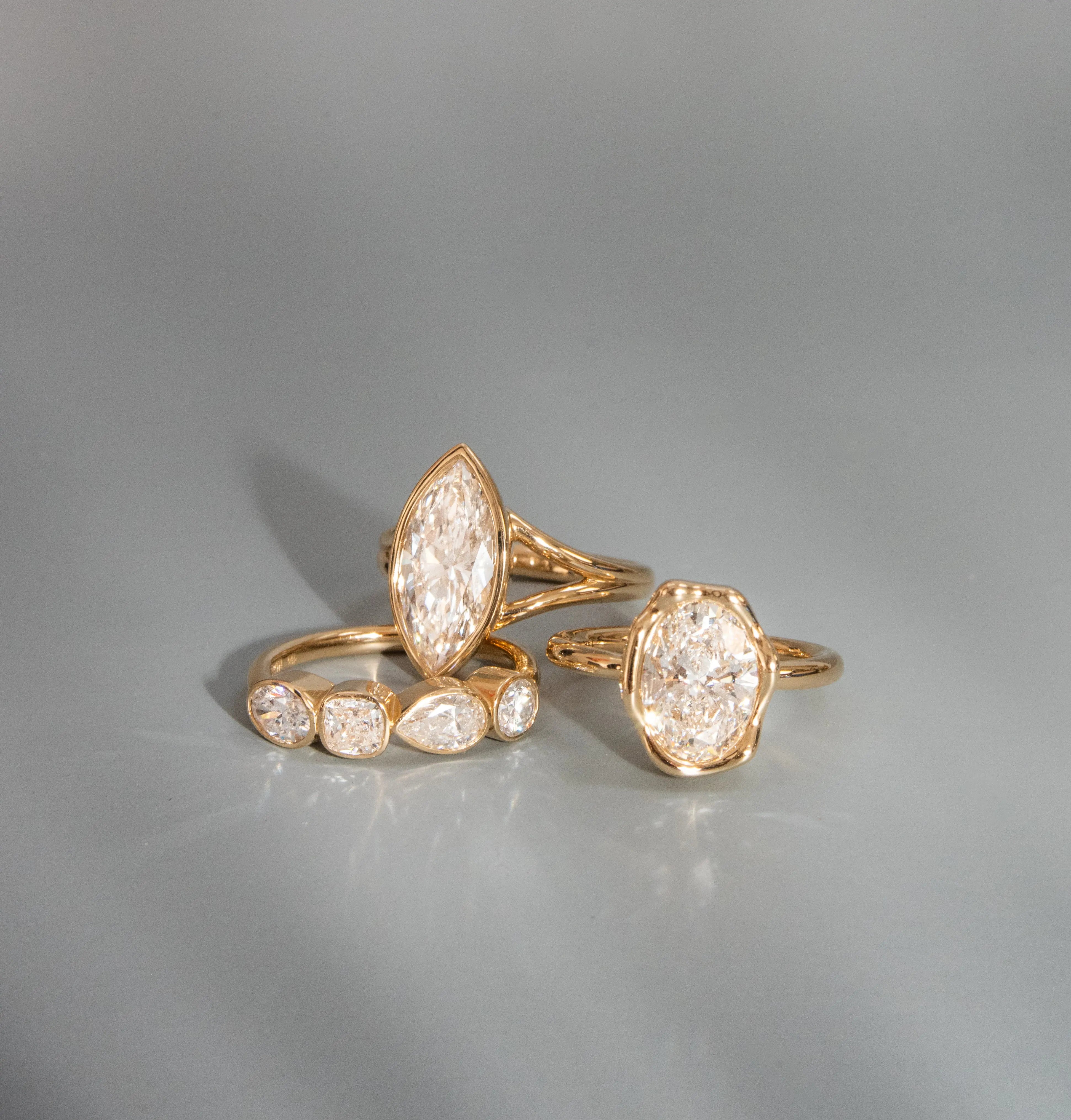 Gold rings with diamond accents on a gray background