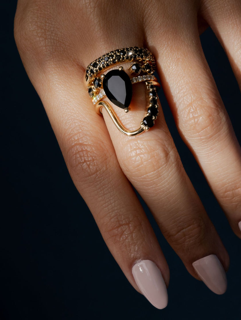 Close up of woman's hand with a stack of 4 rings - all black diamond or onyx