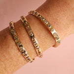 3.30tcw Fancy Tanzanite Cuff + 2.02tcw Tanzanite Cuff + 6.41tcw Fancy Tanzanite Cuff stacked on woman's wrist, close up
