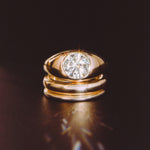 The Dyllan Engagement Ring flat lay with solid gold bands beneath