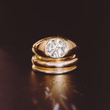 The Dyllan Engagement Ring flat lay with solid gold bands beneath