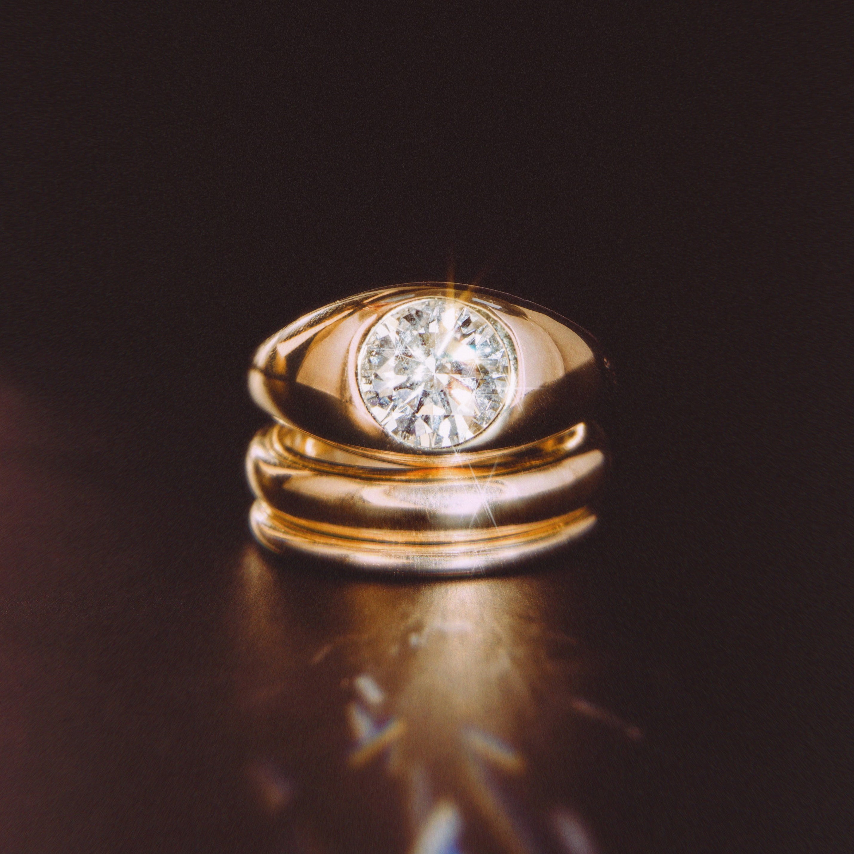 The Dyllan Engagement Ring flat lay with solid gold bands beneath
