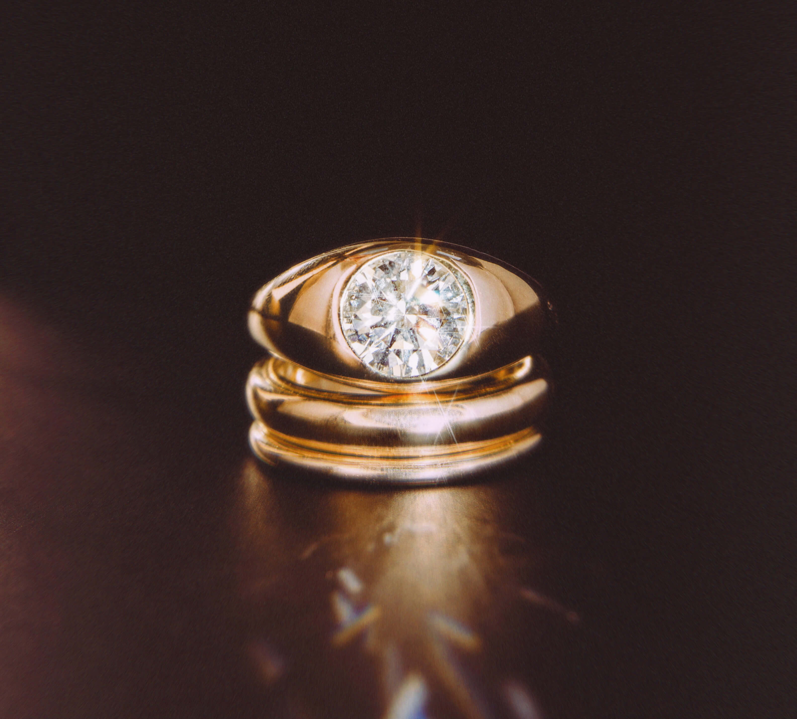 Gold ring with a diamond on a dark background