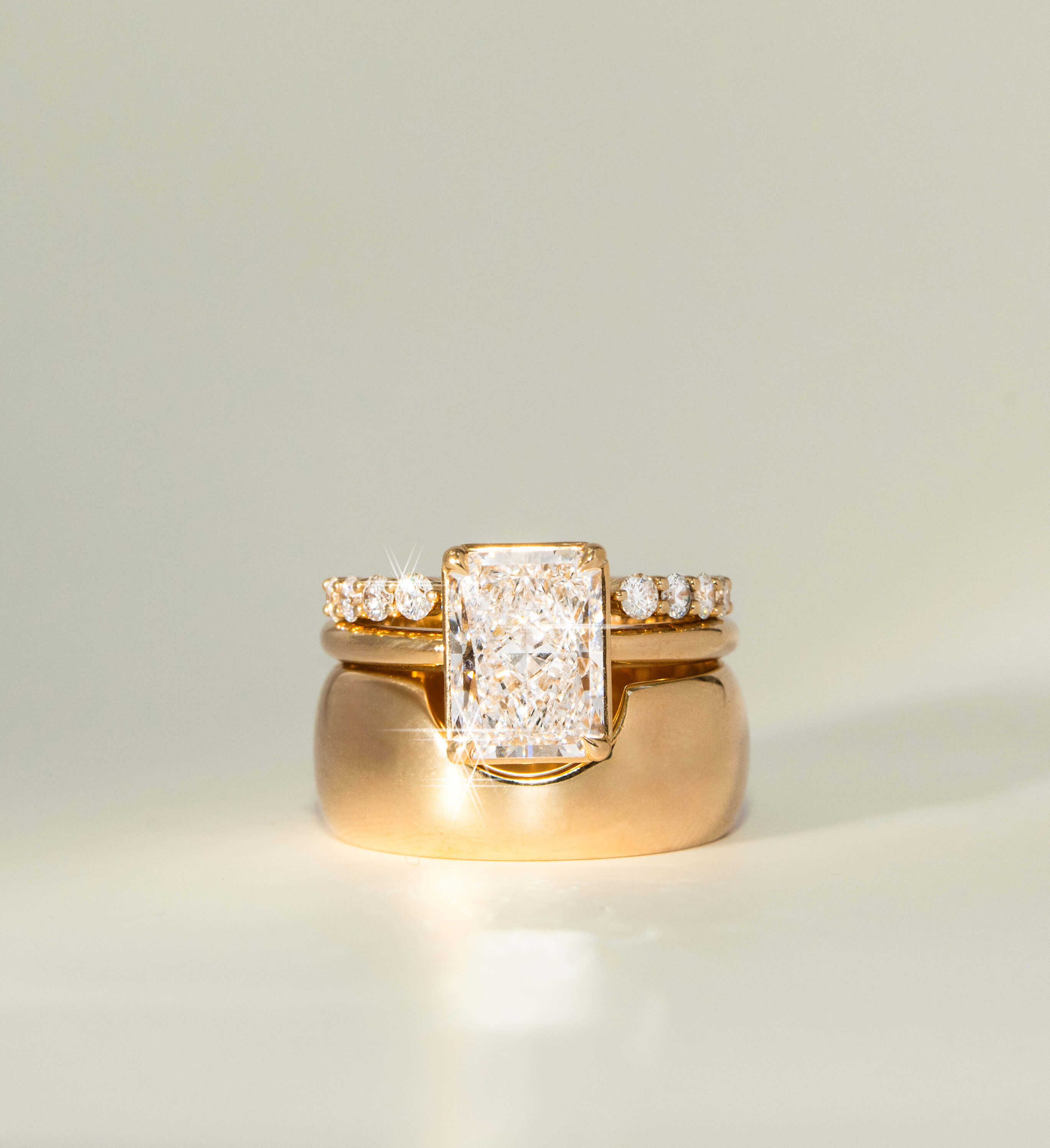 Gold ring with diamond accents on a light gray background