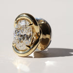 Gold charm with a large diamond on a light gray background