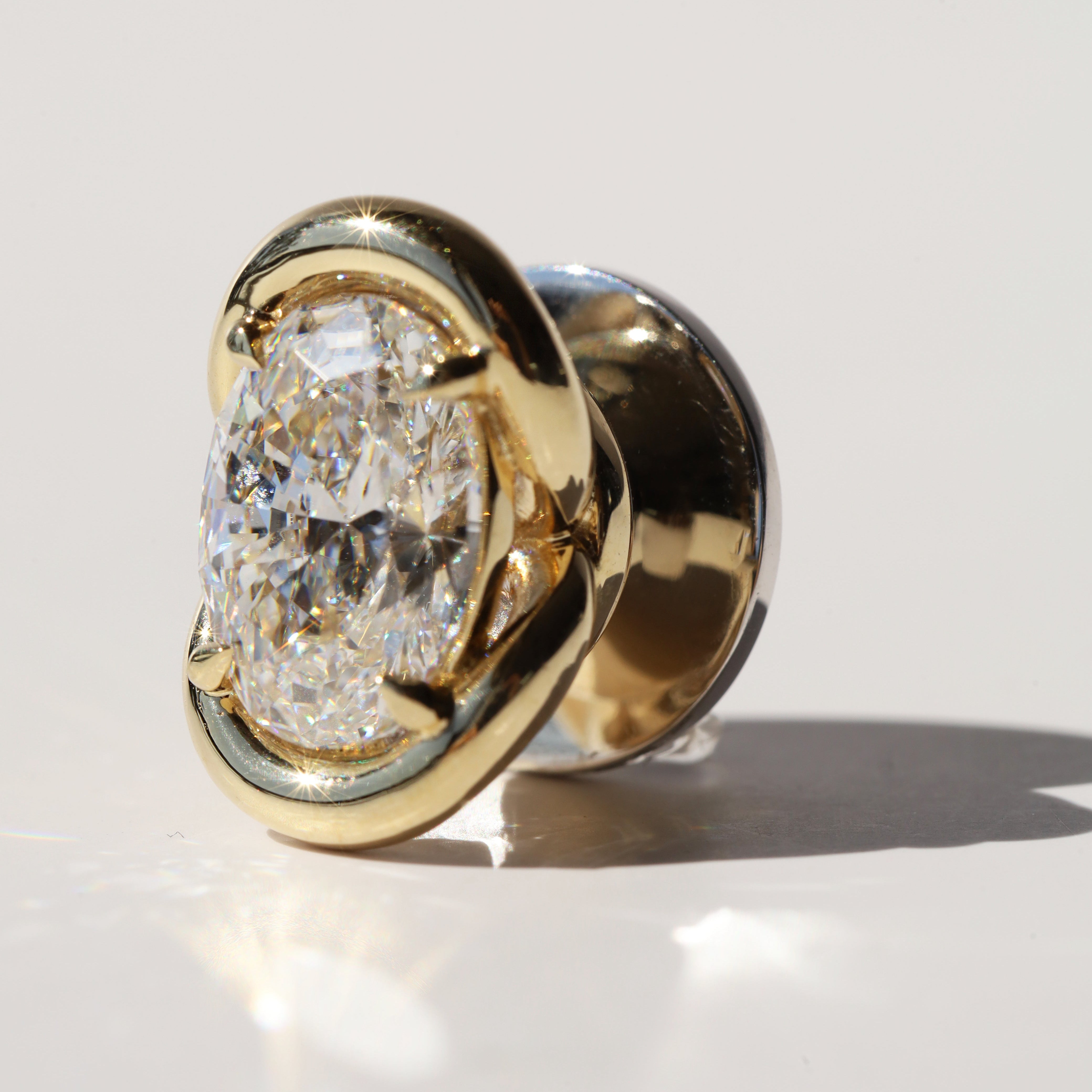 Gold charm with a large diamond on a light gray background