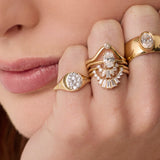 Close up of woman resting hand agains her chin, highlighting multiple Marrow Fine diamond rings