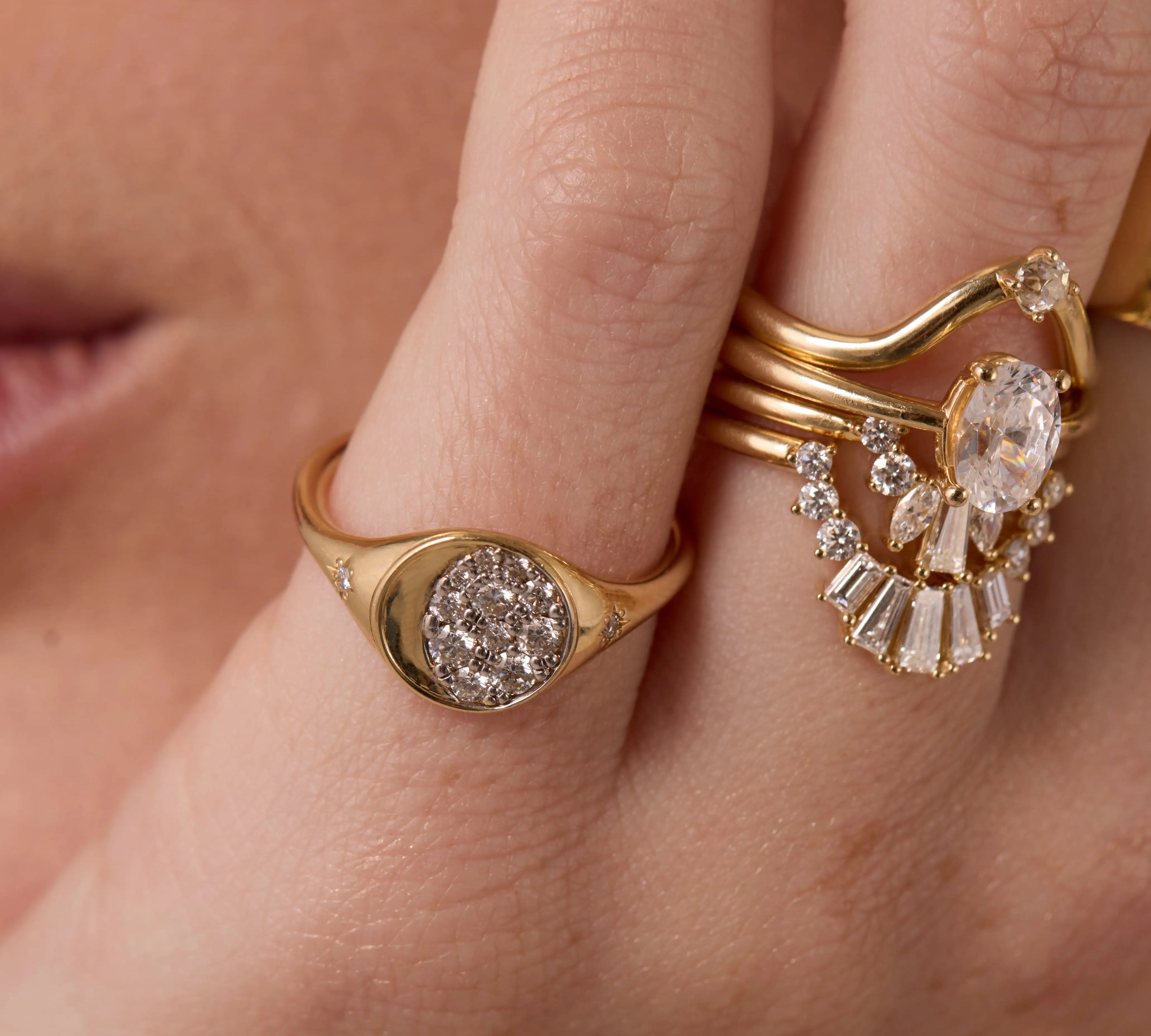 Close up of woman resting hand agains her chin, highlighting multiple Marrow Fine diamond rings