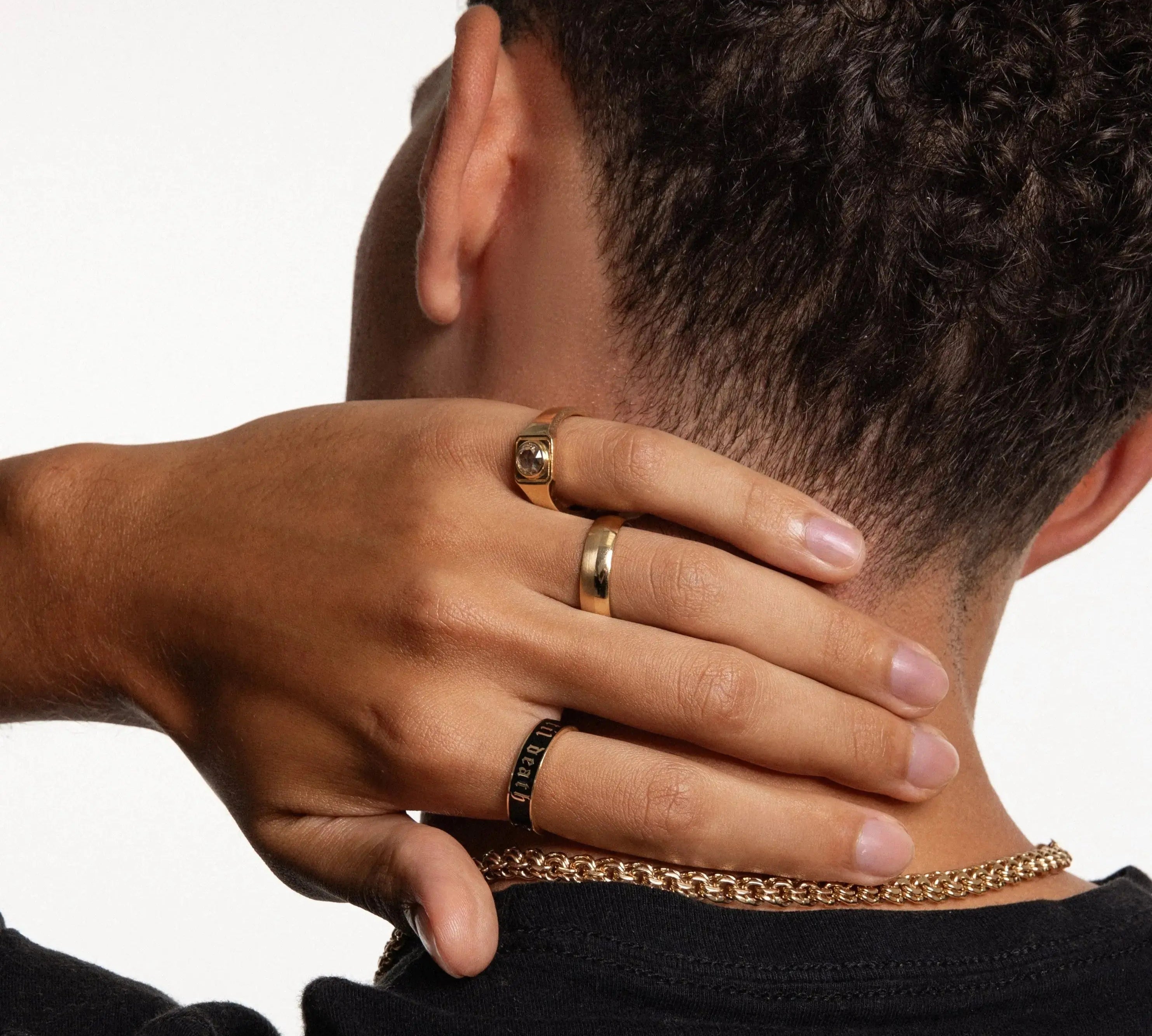Close up of man's hand against back of his neck featuring multiple Marrow Fine men's bands