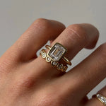 The Roxy Bezeled Emerald Cut Engagement Ring on hand