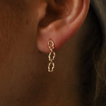 Close up of woman's ear featuring the Marrow Fine 6mm Sculpted Link Gold Earrings