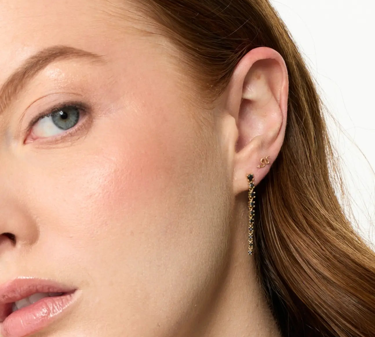 Close-up of a woman's ear with an earring on a white background