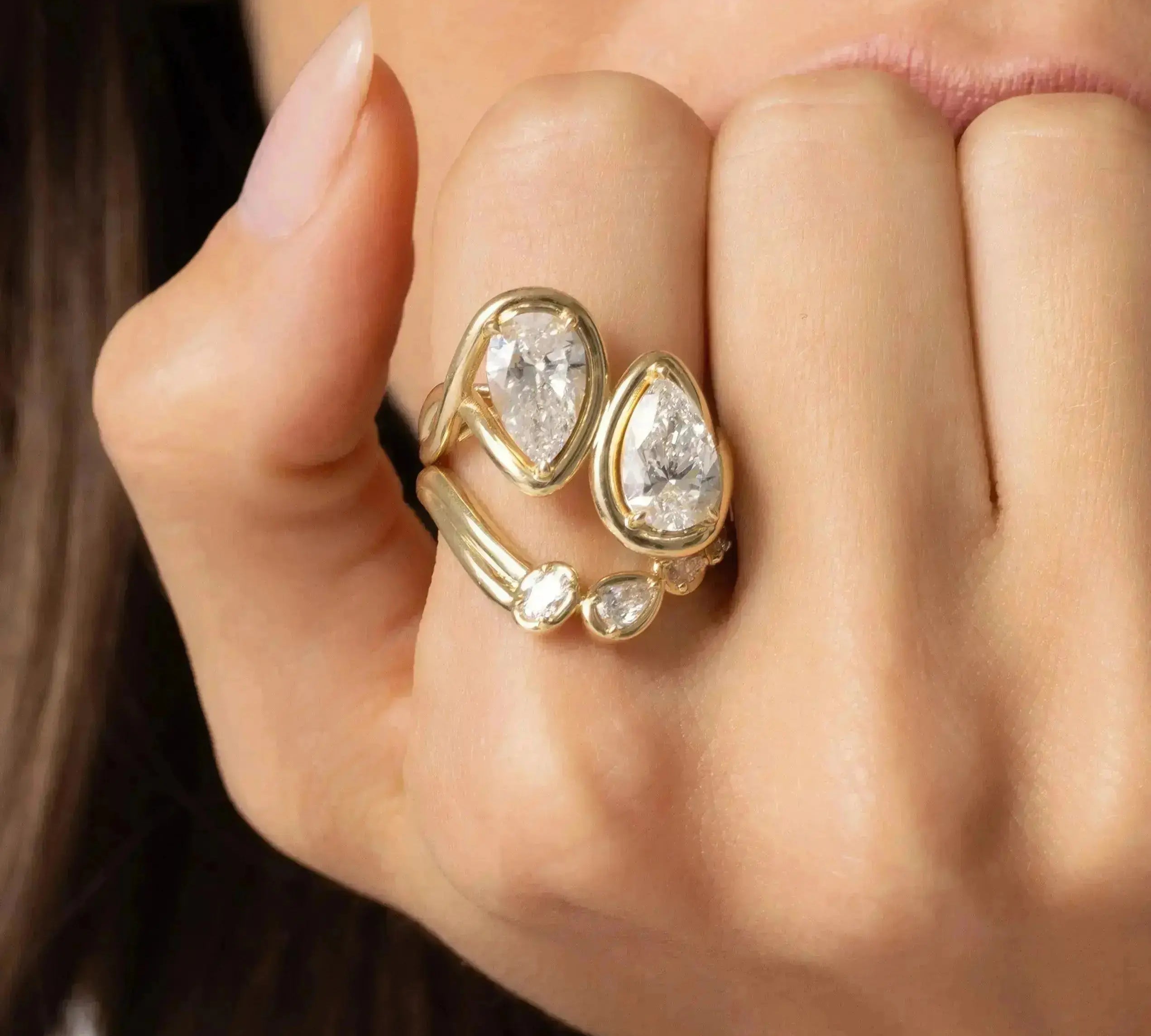 Close up of Joanie Bypass Ring and Simone Arch Band stacked on woman's finger