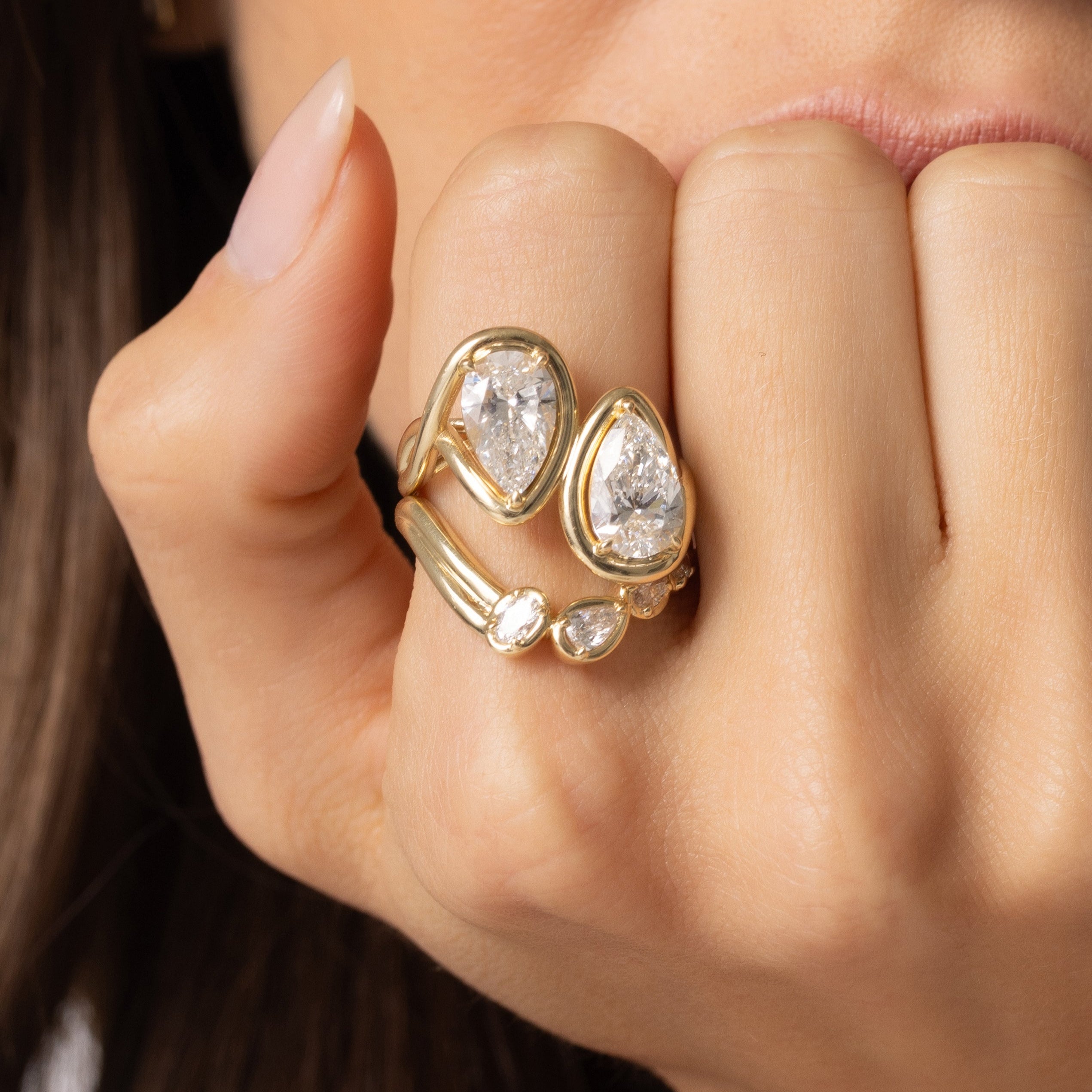 Close up of Joanie Bypass Ring and Simone Arch Band stacked on woman's finger