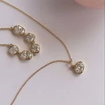 Gold necklace with diamond pendants on a light background