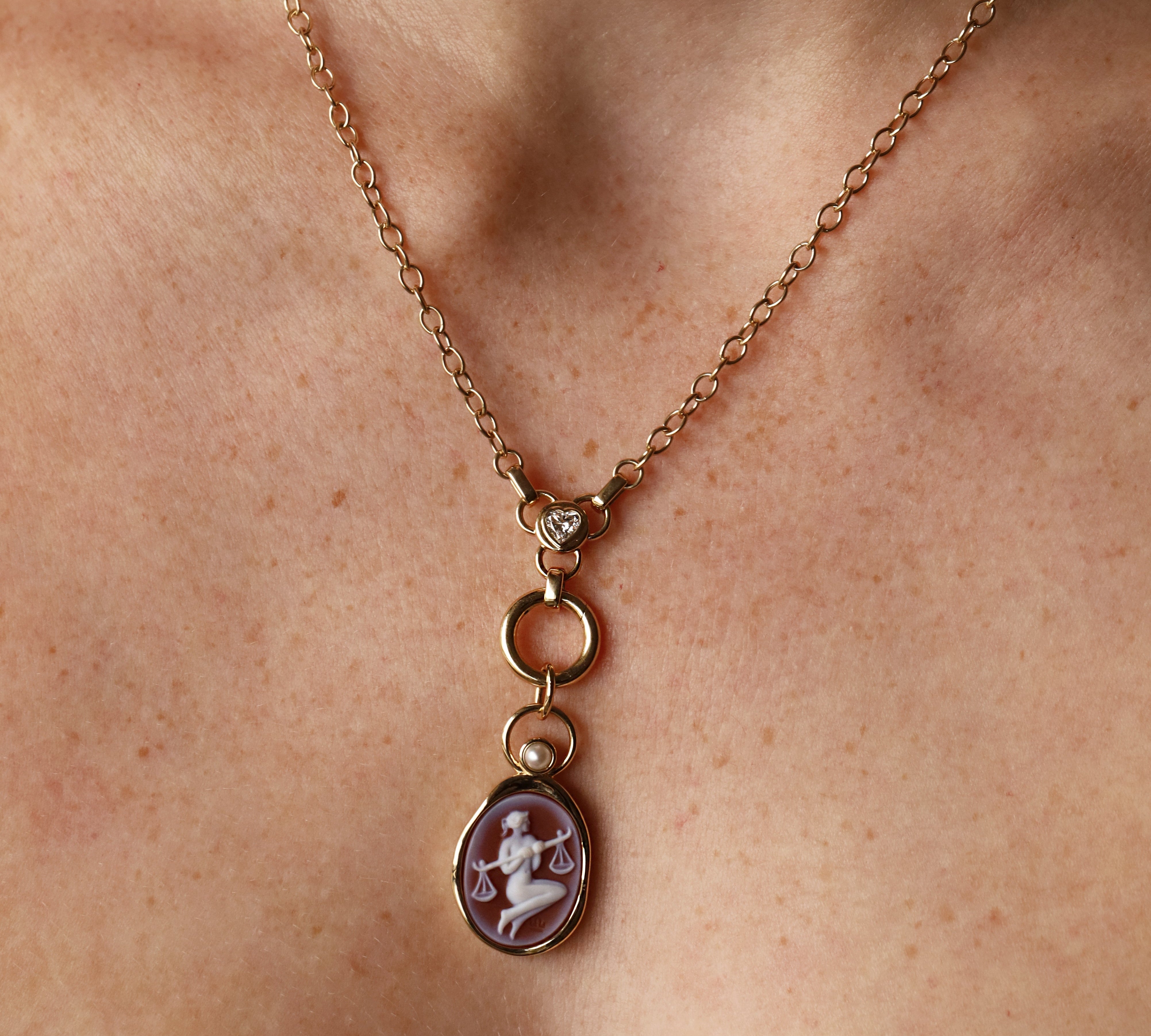 Libra Zodiac Orange Agate Carving with Pearl pendant – Libra holding her scales carved in white on orange agate in 14k yellow gold, with a white pearl floating in an open gold ring