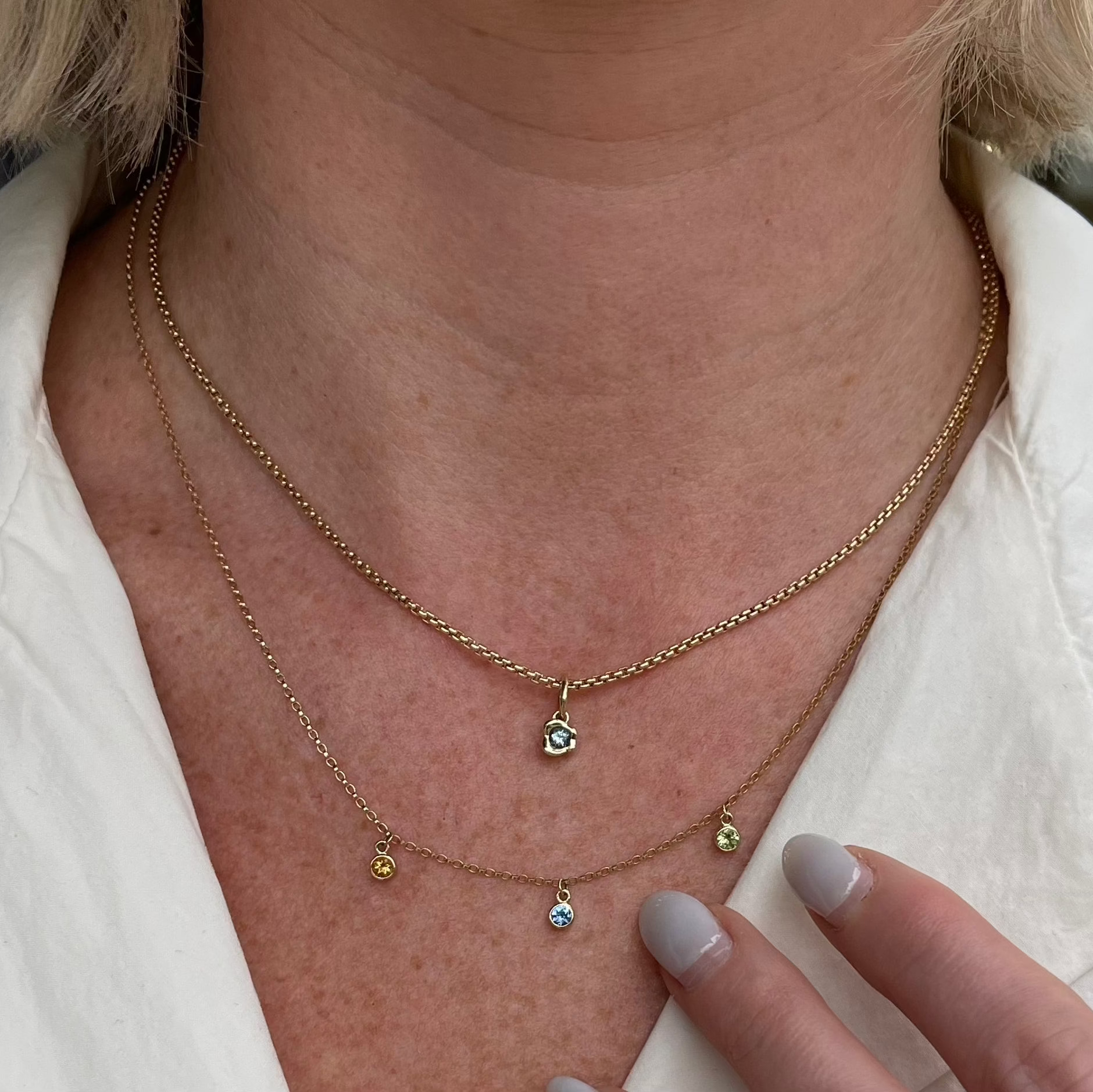 Close up of Abstract Bezel Charm on woman's décolletage