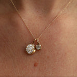 Gold necklace with two pendants on a person's neck