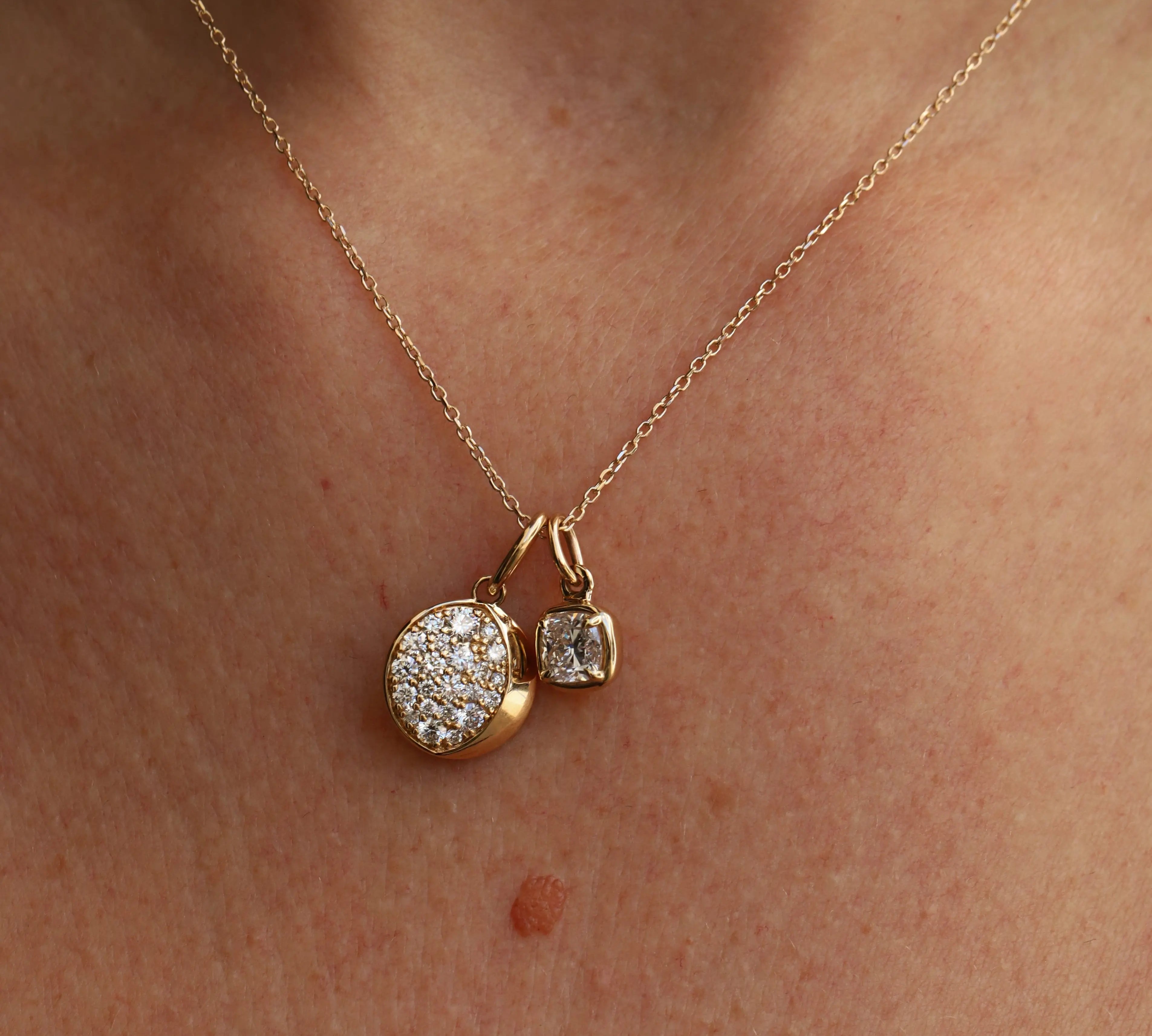 Gold necklace with two pendants on a person's neck