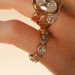 close up of woman's hands wearing multiple yellow gold and diamond rings