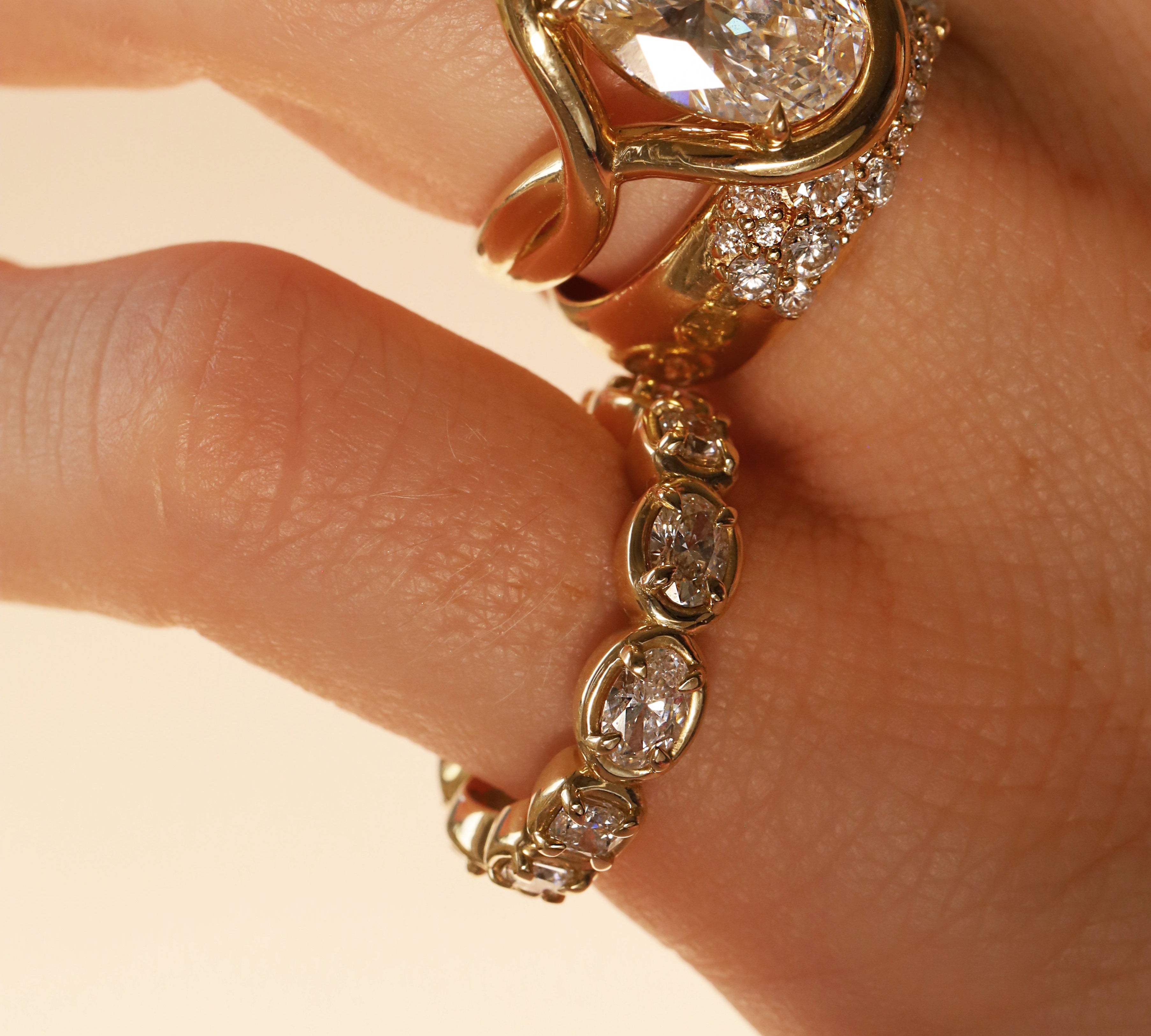 close up of woman's hands wearing multiple yellow gold and diamond rings